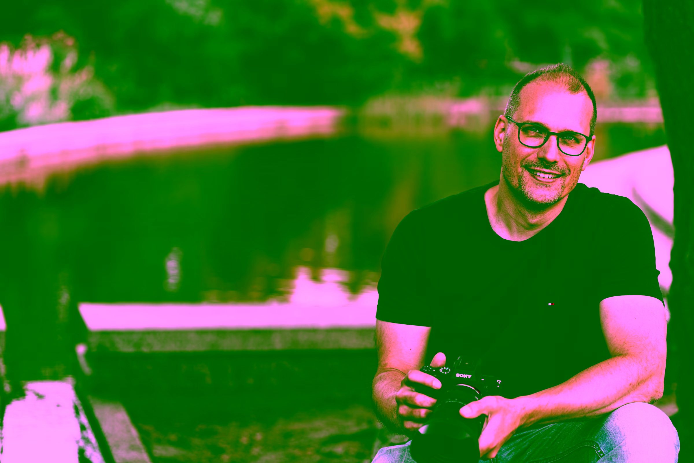 Portrait eines Fotografen mit Kamera an einem Wasserbecken
